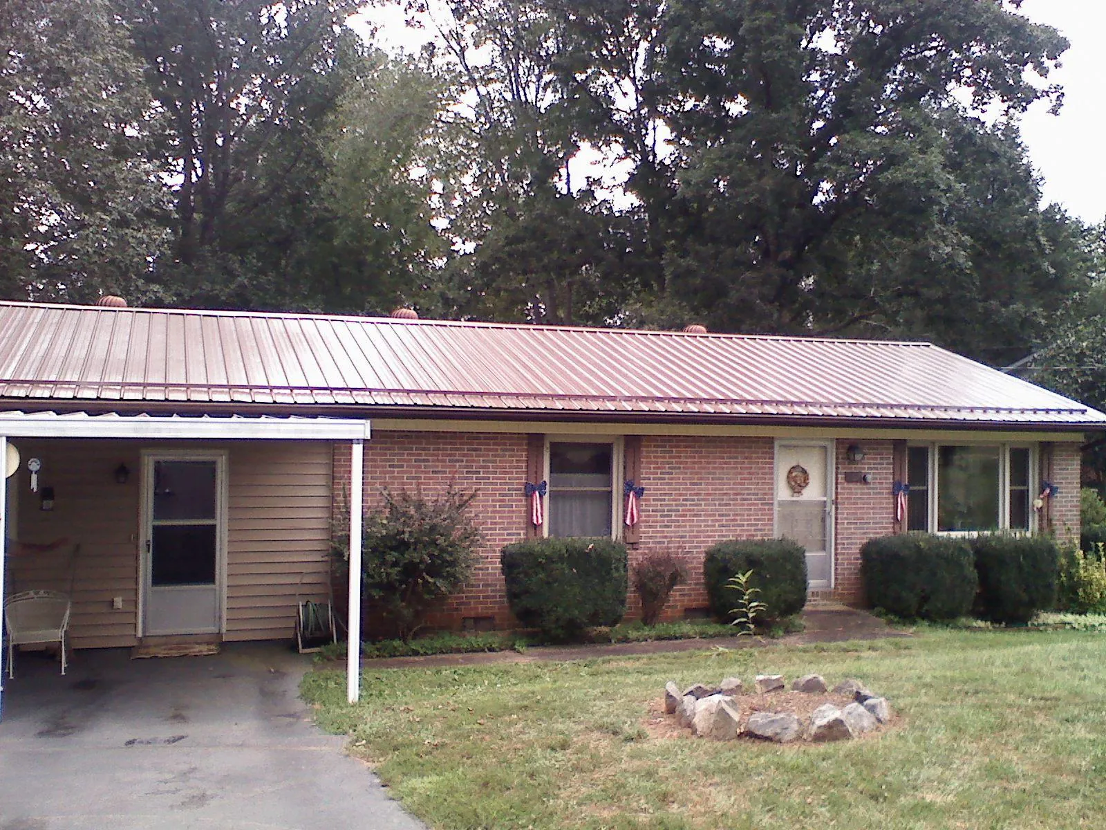 Bronze metal roof and carport on a brick ranch home — Roof Repair work by our crew in Cedar Falls